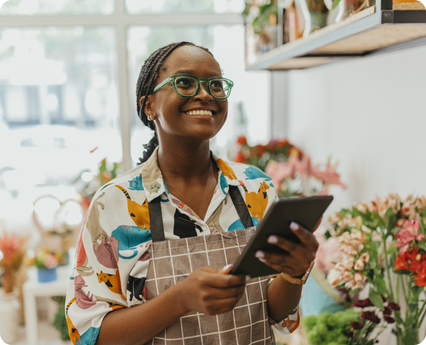 Smiling florist holding a tablet in her flower shop, for the Zip guide to custom buy now, pay later API integration