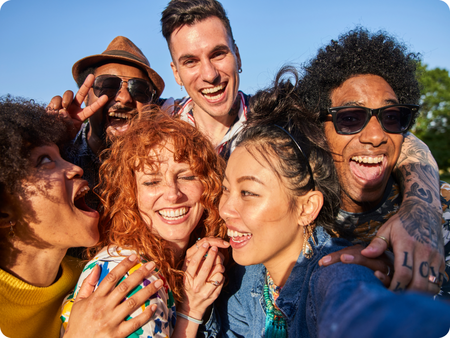 Group of smiling friends taking a selfie outdoors, illustrating premium and group ticket sales with Zip buy now, pay later