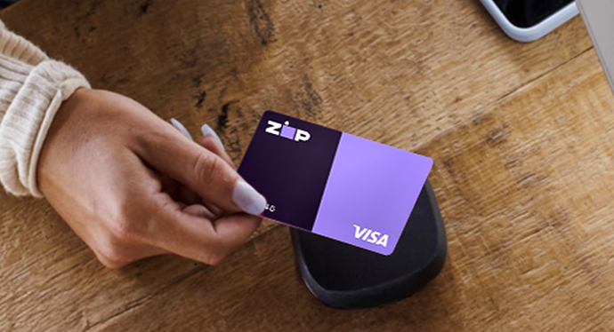 Hand tapping a Zip Visa card on a payment reader, the cover image for the ultimate buy now, pay later guide for merchants