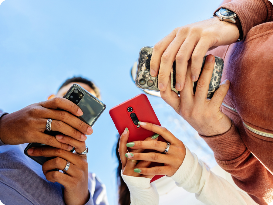 Low-angle view of friends checking their phones together to buy event tickets with Zip buy now, pay later