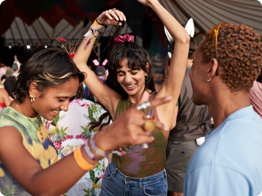 Friends dancing at an outdoor music festival, illustrating event tickets purchased with Zip buy now, pay later