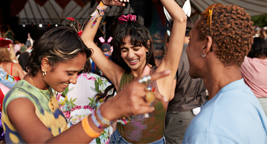 Friends dancing at an outdoor music festival, illustrating event tickets purchased with Zip buy now, pay later