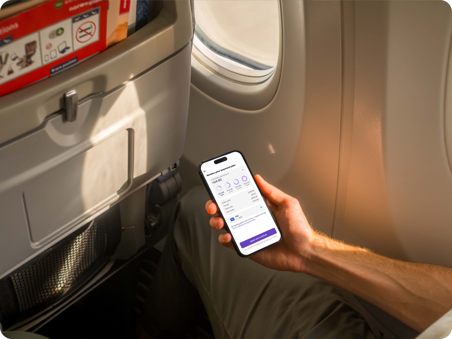 Passenger on a plane holding a phone showing a Zip payment plan to split the cost of travel with buy now, pay later