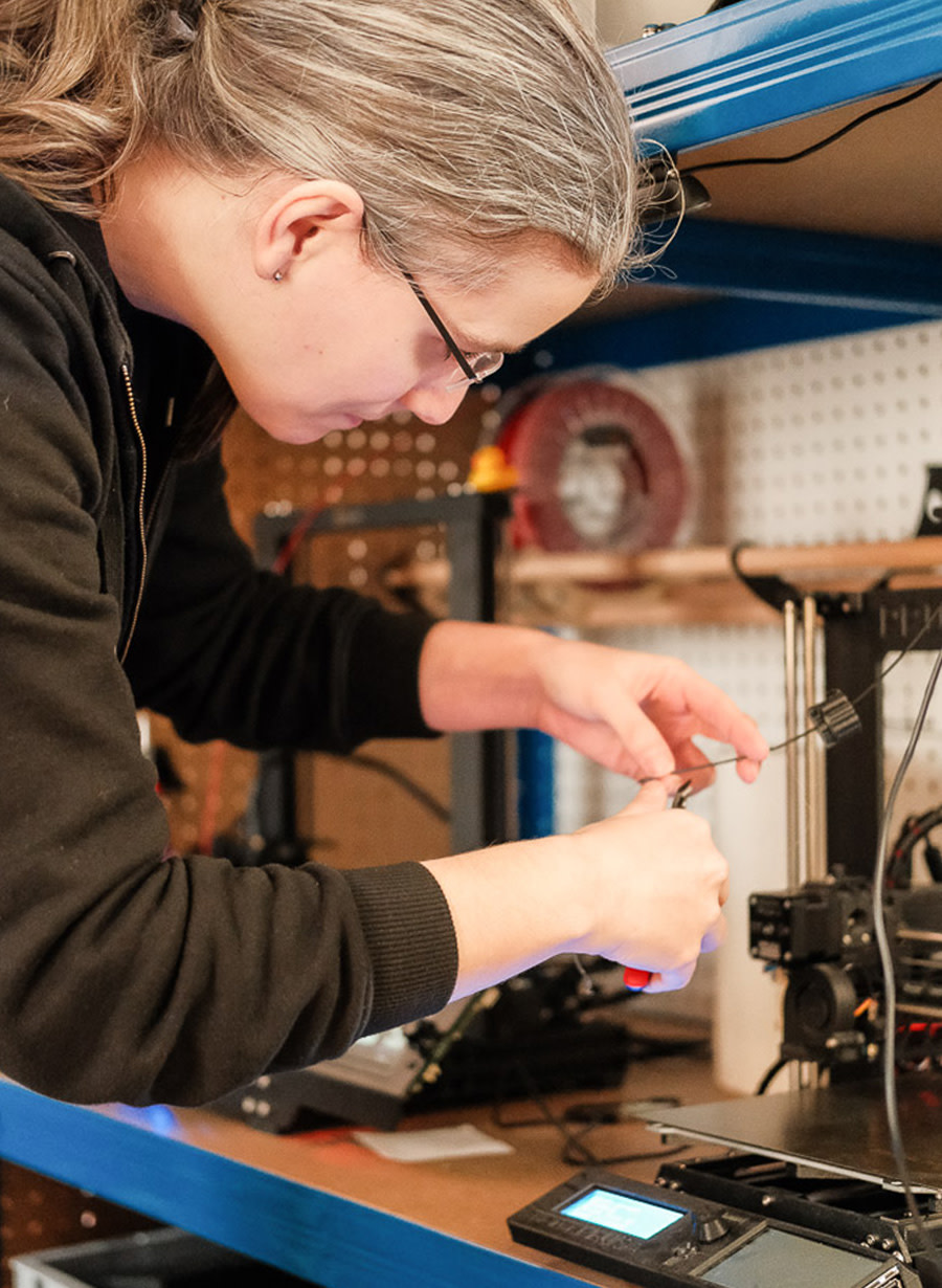 Photo of Gina Häußge working with a 3D printer.