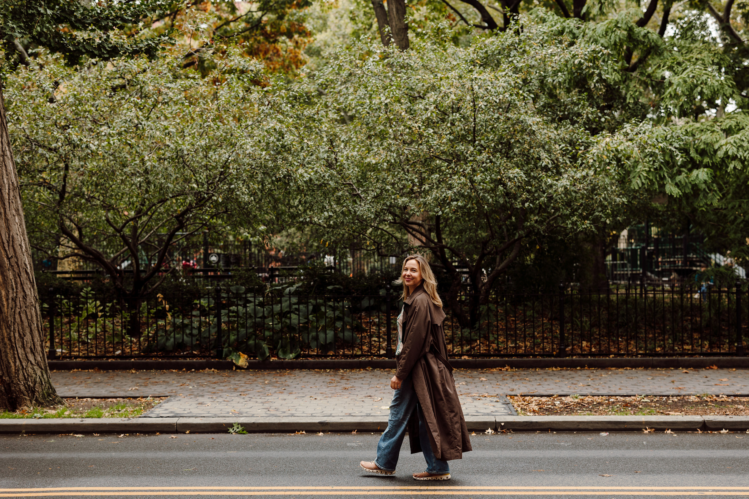 Author Jana walking on a road in front of a park