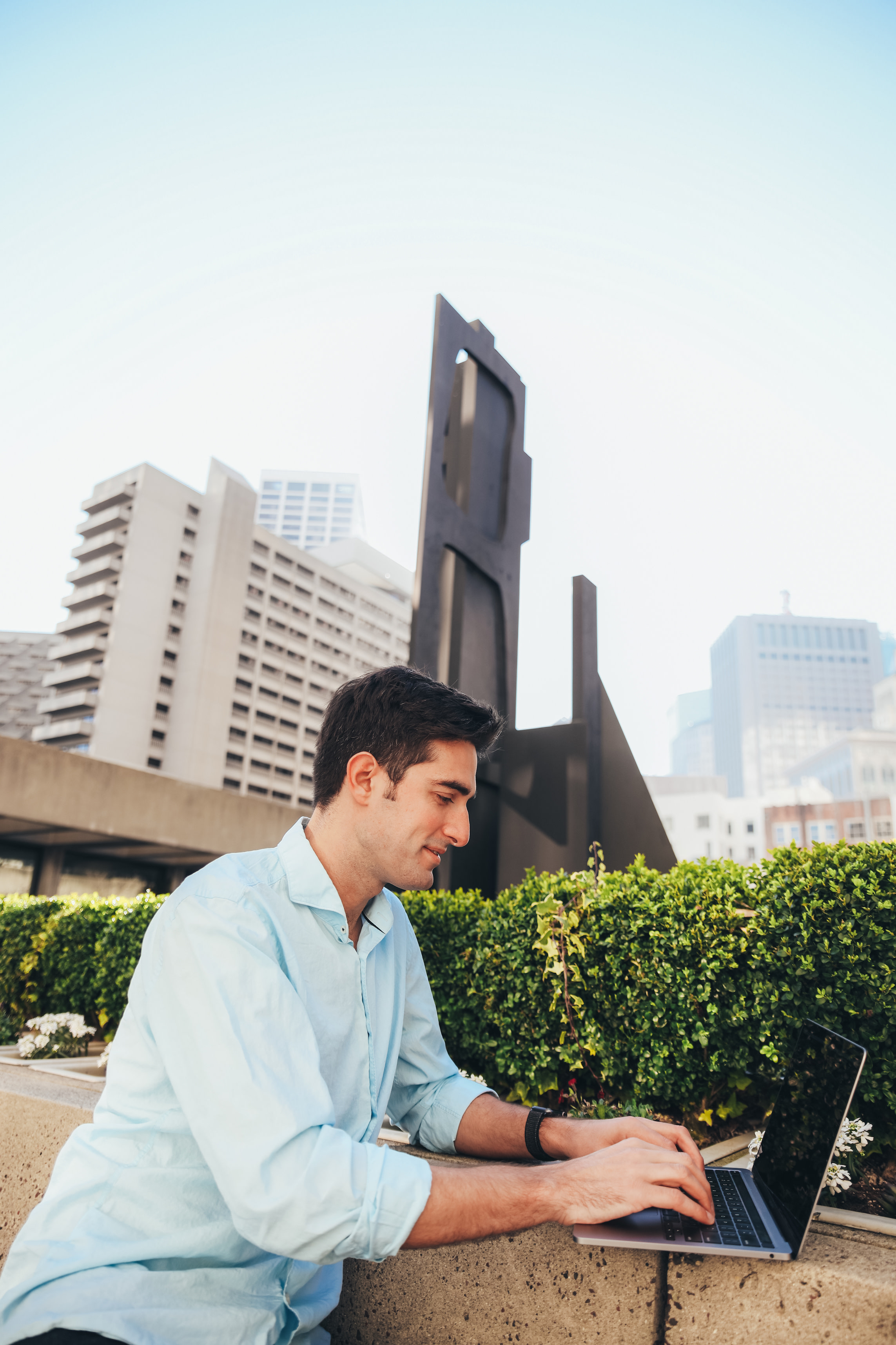 Author Feross working on his laptop outside in an urban landscape
