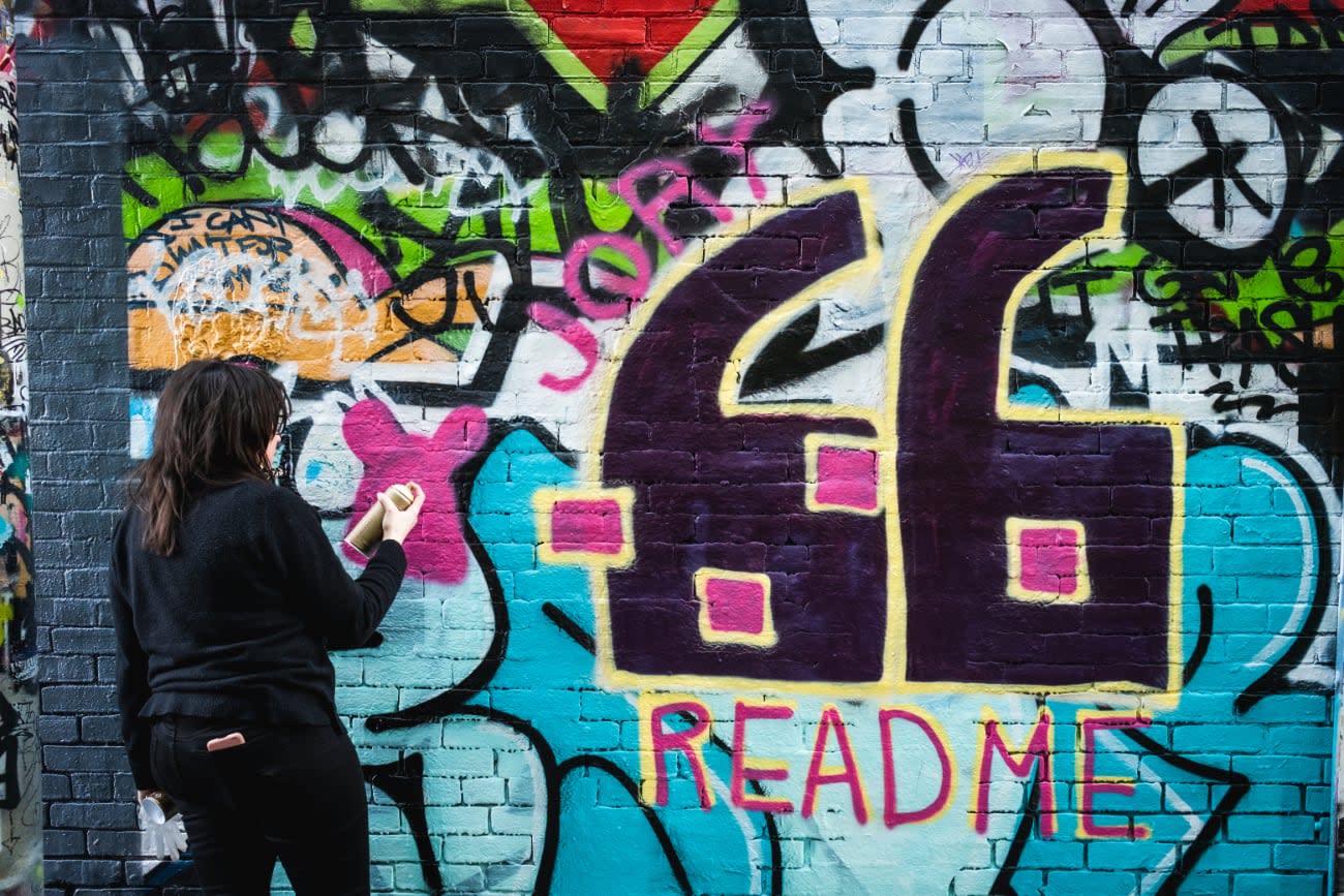 Photo of Jory Burson finishing her ReadME Project street art.
