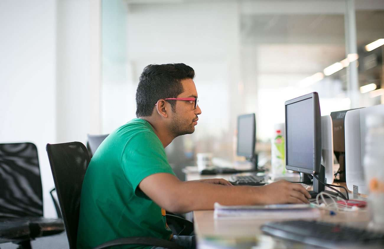 Man sitting at desk with computer screen.