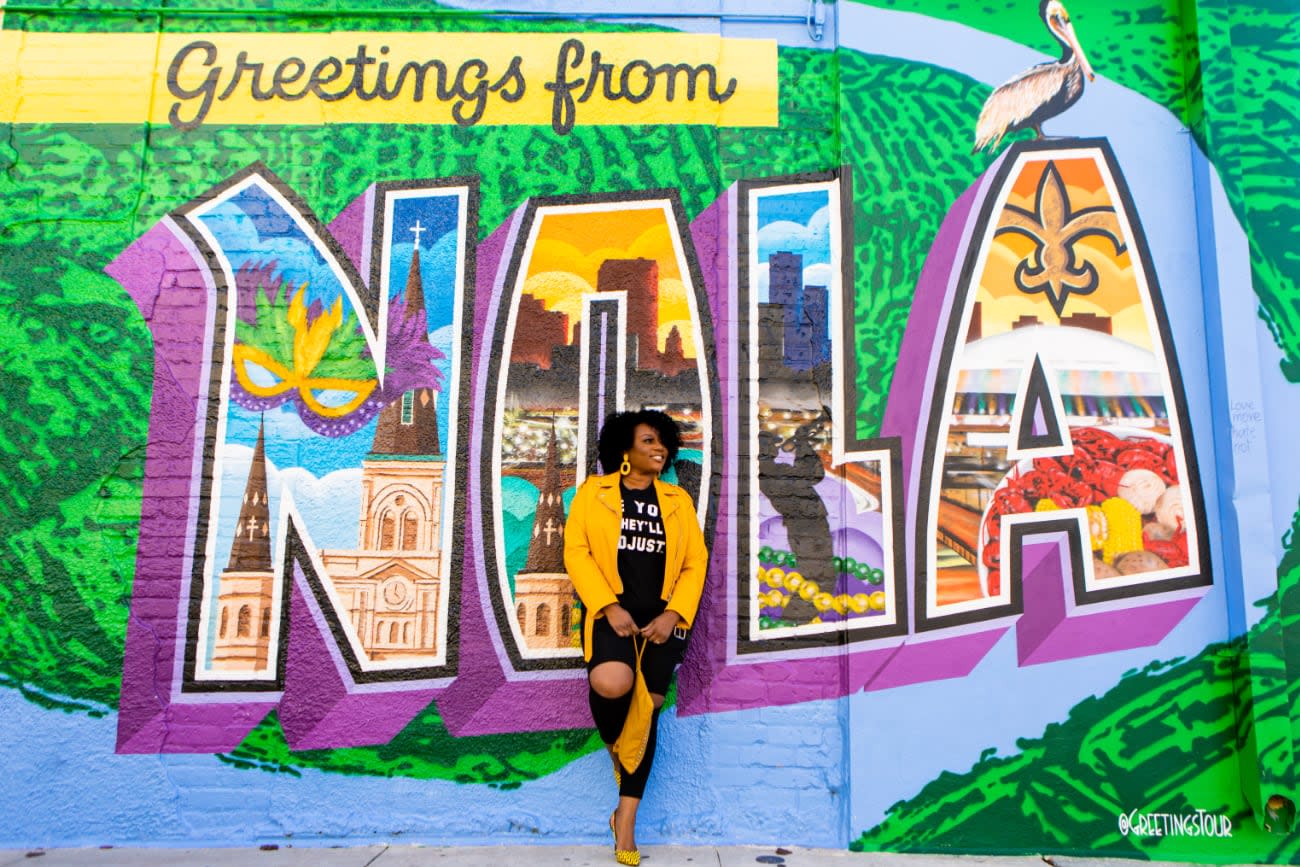 Photo of Angie Jones posing in front of street graffiti.