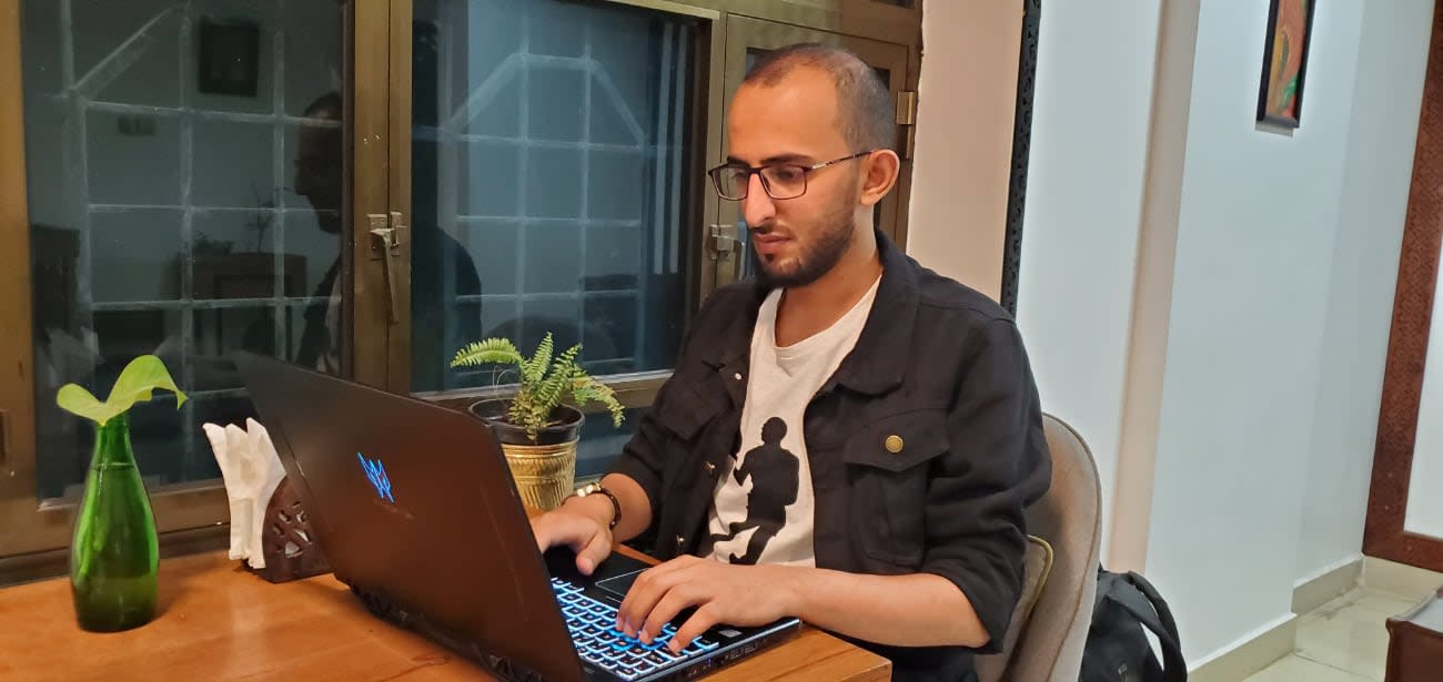 Photo of Salah Al-Dhaferi coding from home on his laptop.