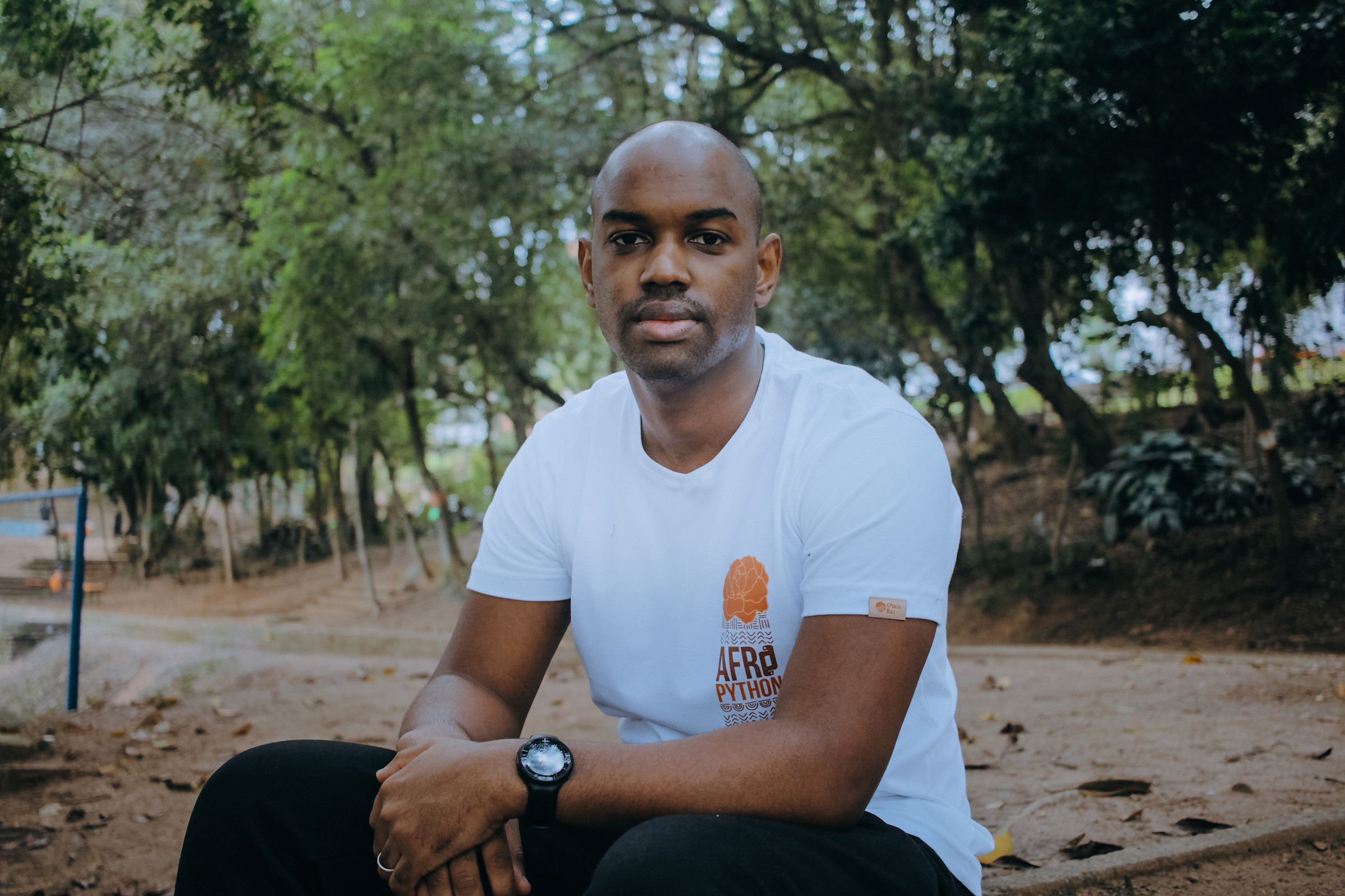 Author Felipe sitting outside in a park and looking straight on at camera