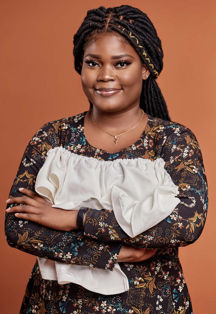 Photo of Gift Egwuenu smiling with arms crossed.