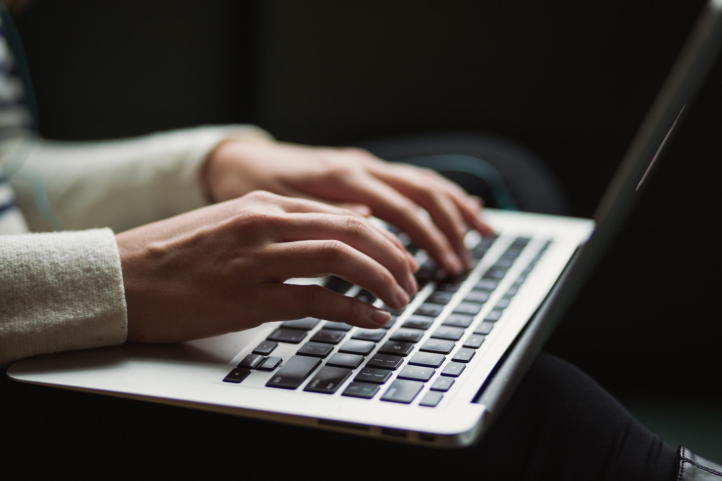 Hands typing on the keyboard of a laptop