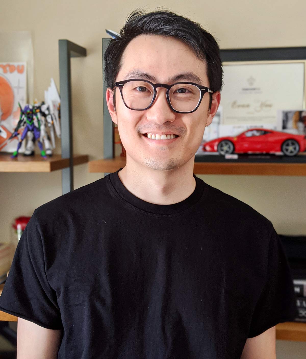 Photo of Evan You smiling in his office adorned with personal memorabilia.