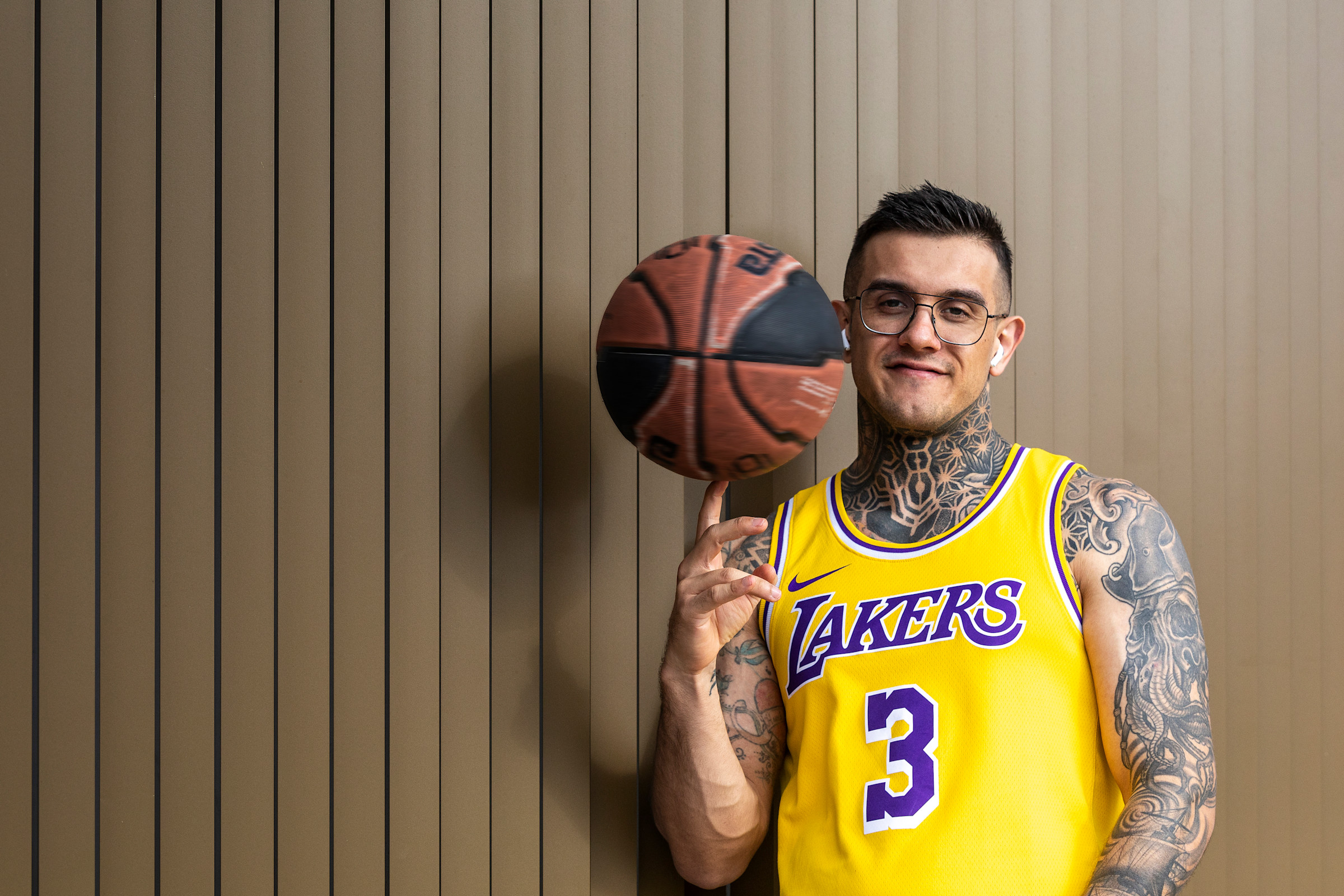 Author Pedro wearing an L.A. Lakers jersey and spinning a basketball