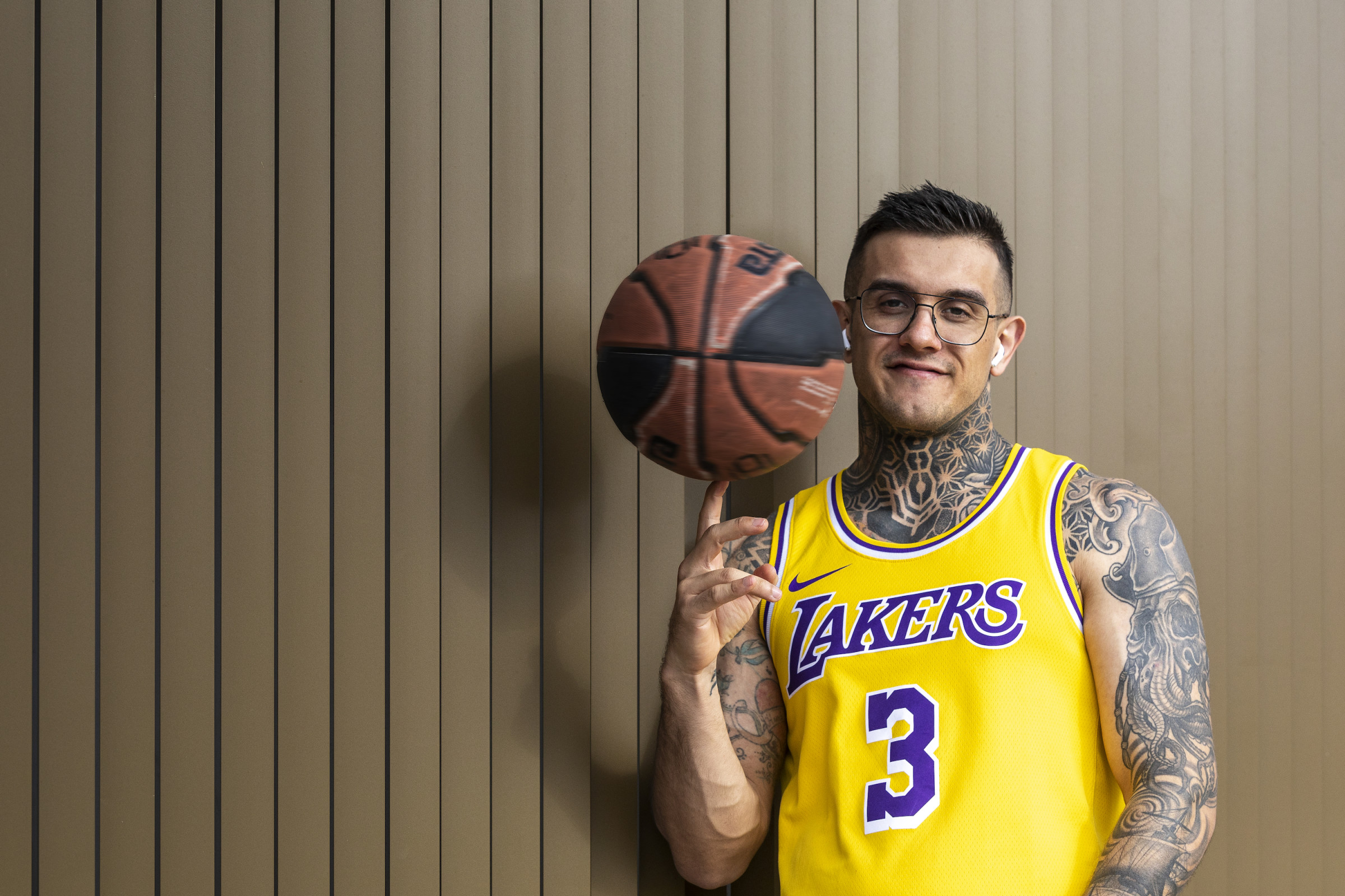 Author Pedro wearing an L.A. Lakers jersey and spinning a basketball