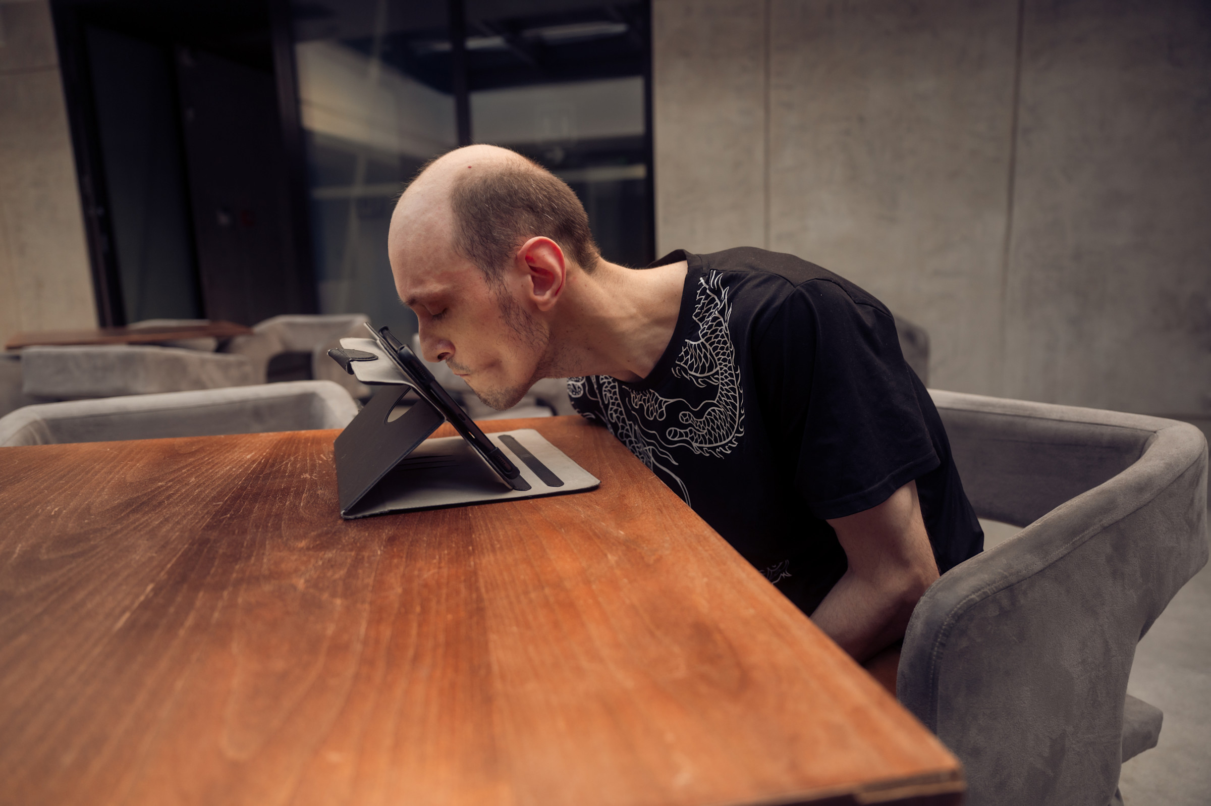 Anton leaning in to a tablet and pressing the screen with his nose.