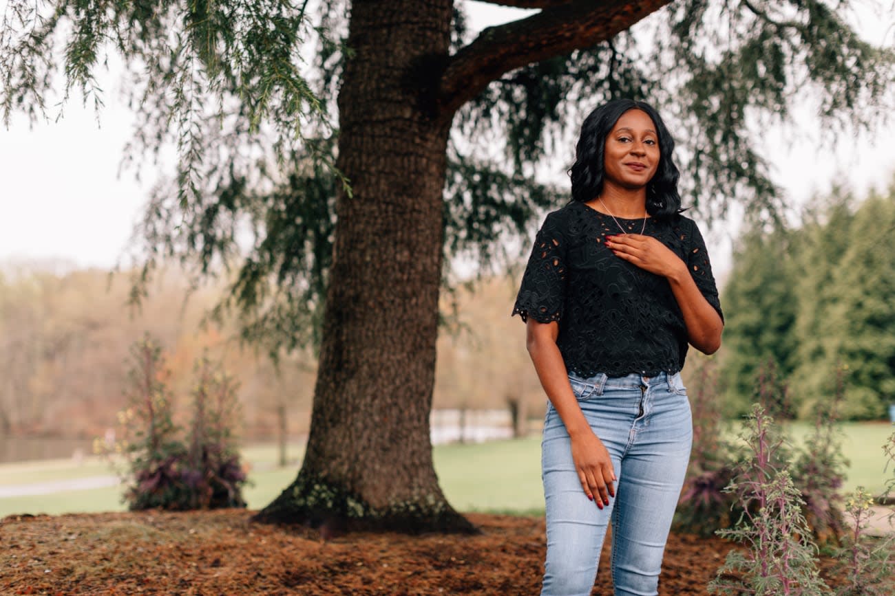 Photo of Monica Powell posing outdoors under a tree.