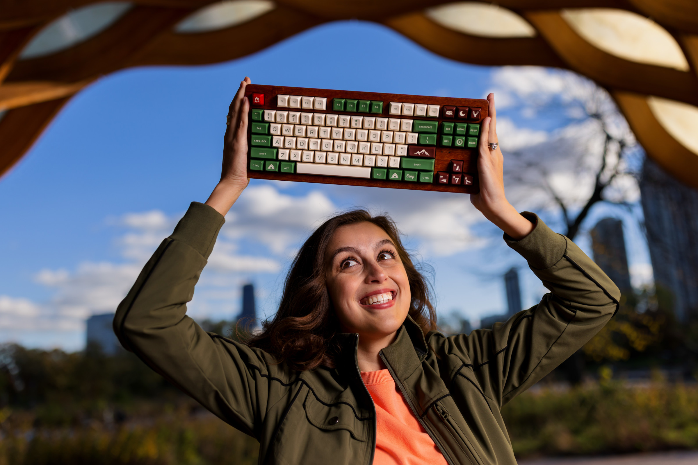 Author Cassidy smiling and holding up a mechanical keyboard she built