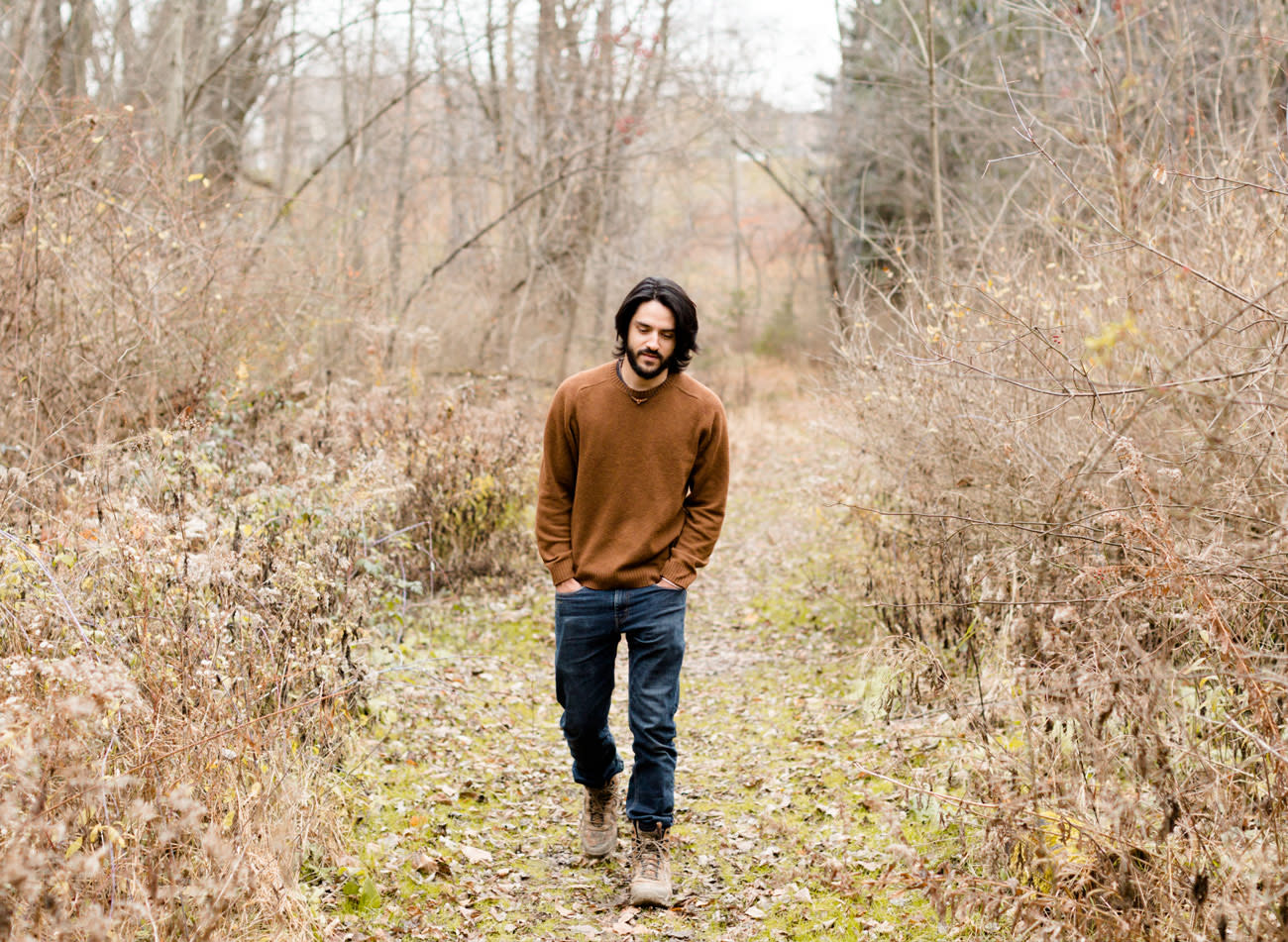 Photo of Caleb Porzio hiking in the woods.