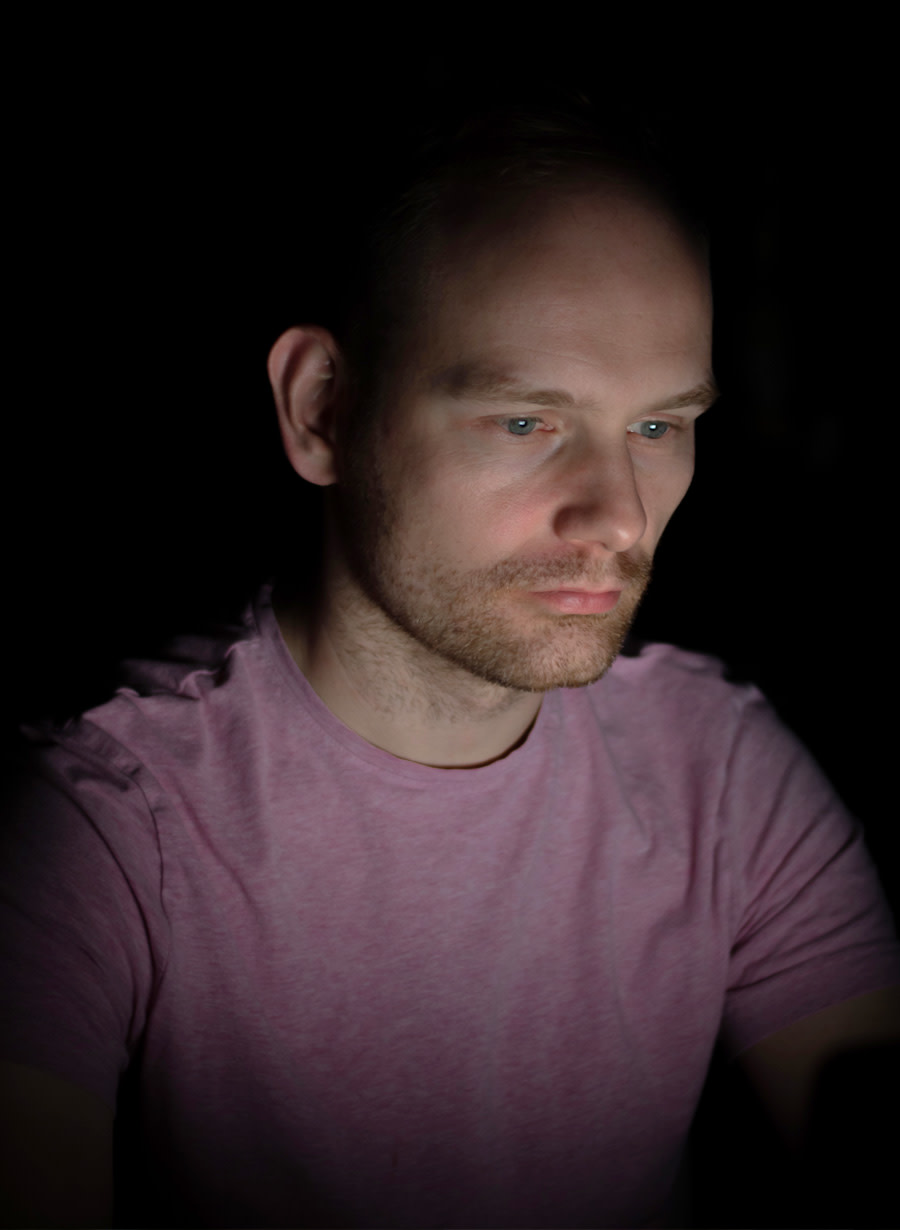 Photo of Michał working in a dark room.