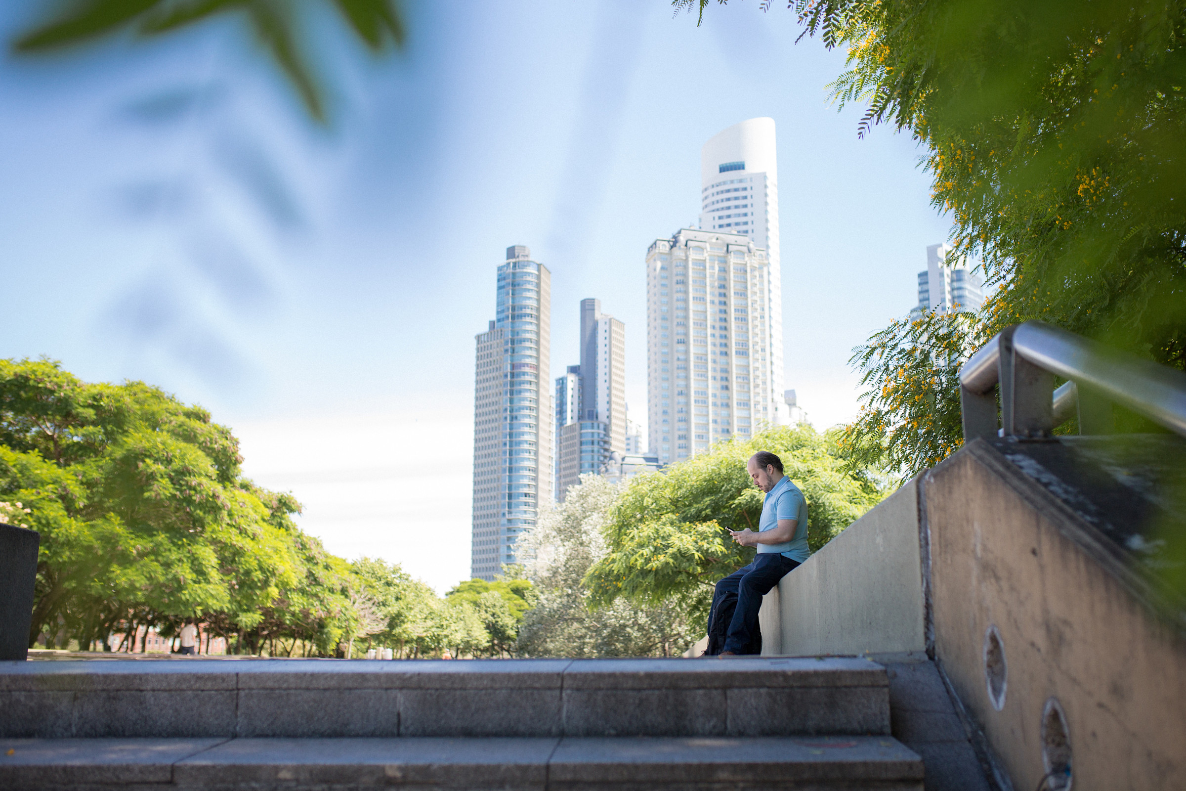 Author Leonardo sitting at the top of a set of stairs in an urban park