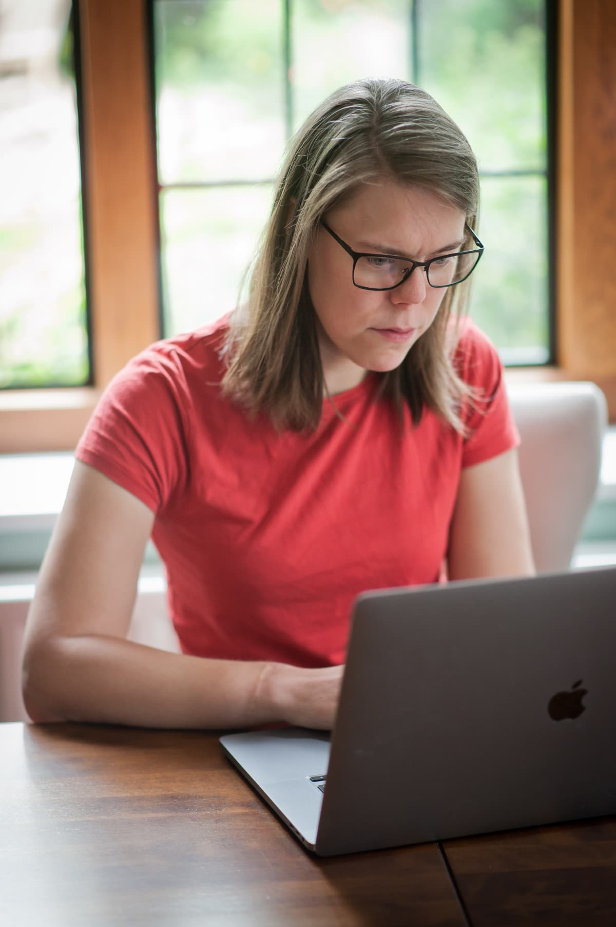 Photo of Issy Long seated in front of their laptop.