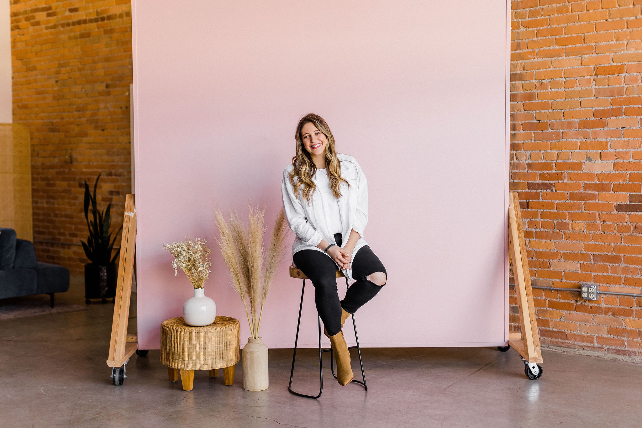 Author Rose sitting on a stool in a studio 