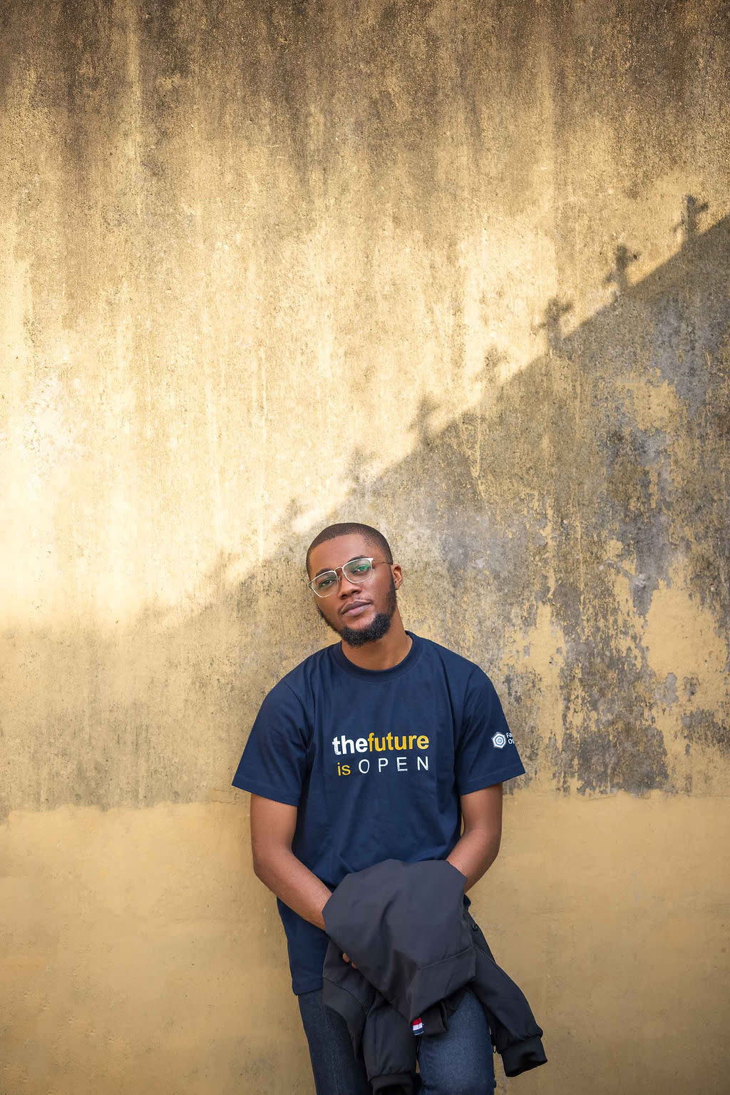 Author Adewale leaning against an outside wall