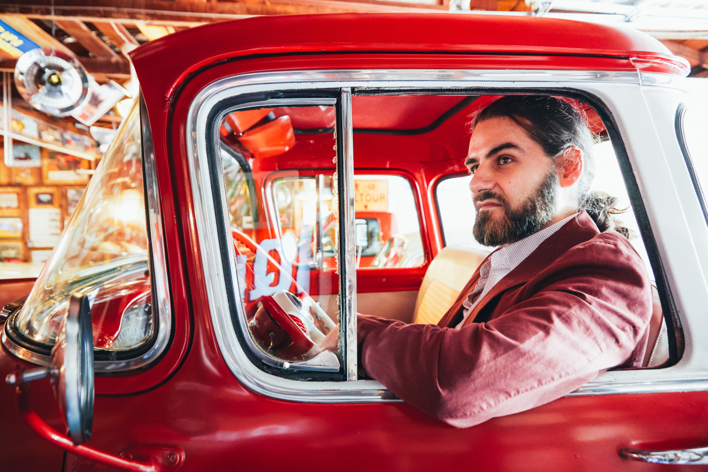 Author Mahmoud sitting in the driver's seat of a red Chevy truck