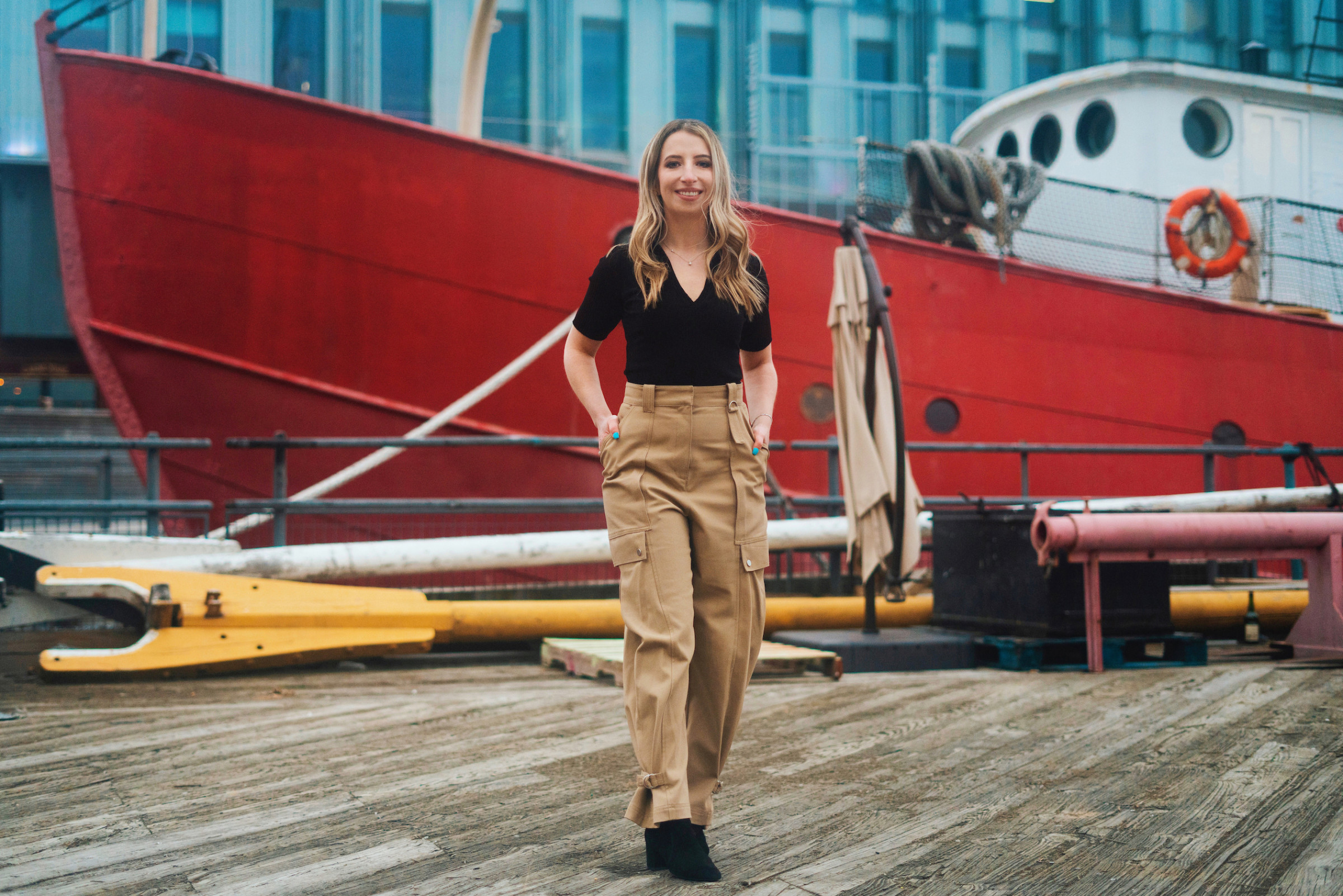 Author Peggy standing in front of a large red tug boat
