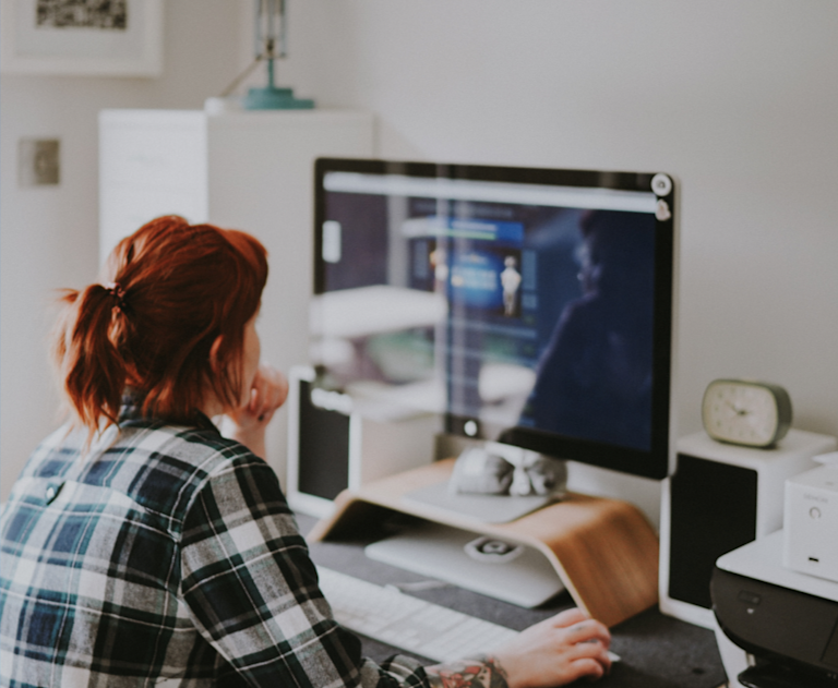 Woman using iMac at home.