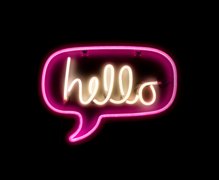 Neon sign of speech ballon with text: 'hello'.