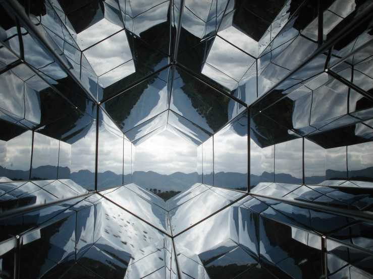 A futuristic looking world reflected by hexagonal mirrors 