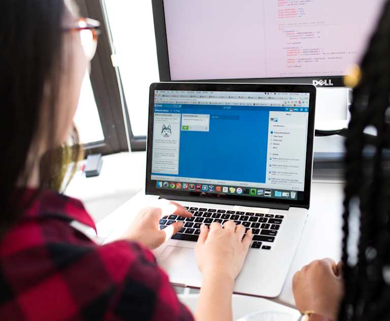 Two developers working at a laptop.