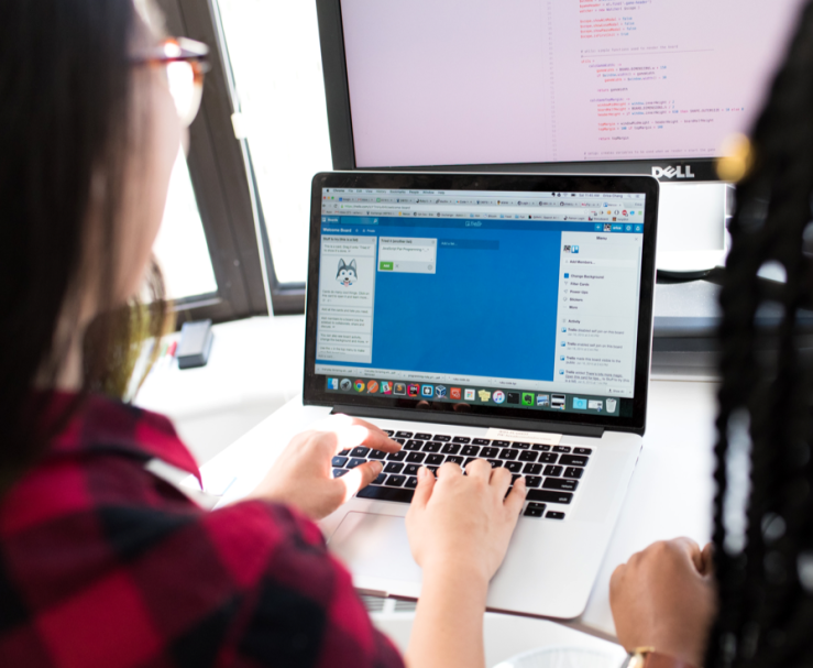 Two developers working at a laptop.