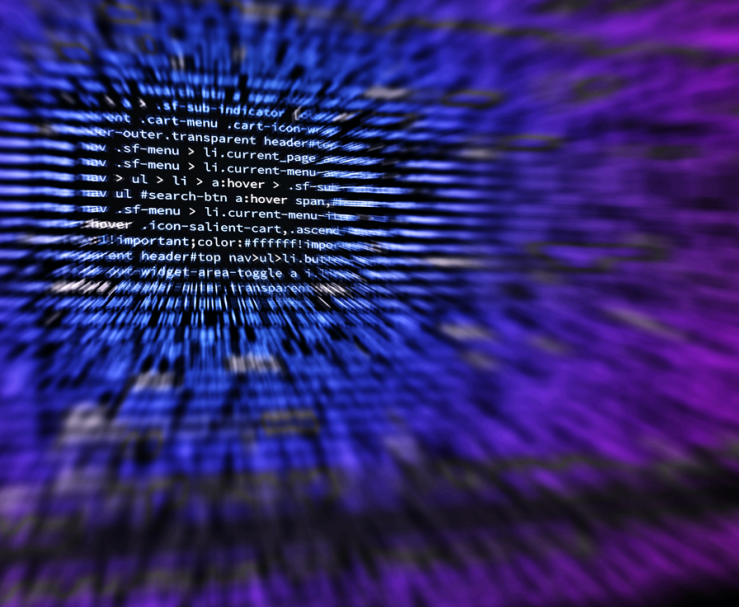 Blurred code on a screen in shades of blue and purple.