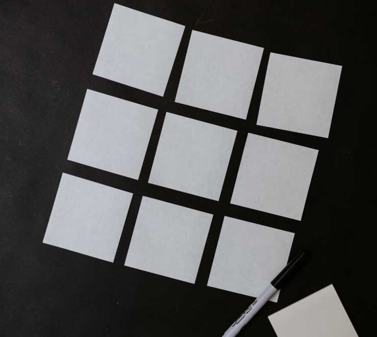 Grid of white sticky notes on a black background 