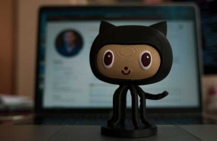  An octocat figurine stands in front of a computer screen