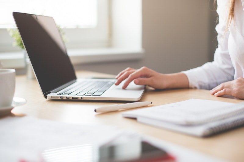 A woman uses a laptop at a desk