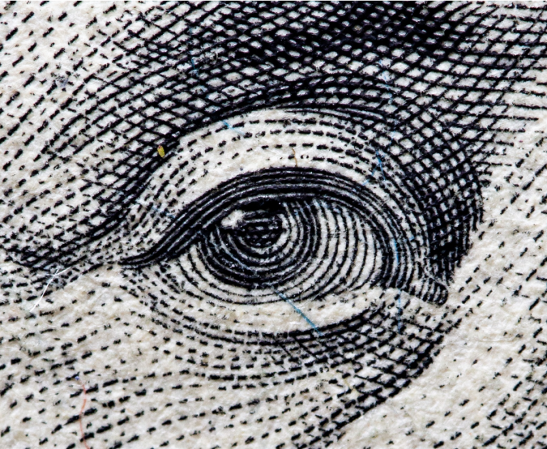 Cropped eye of a person printed on a cash note.