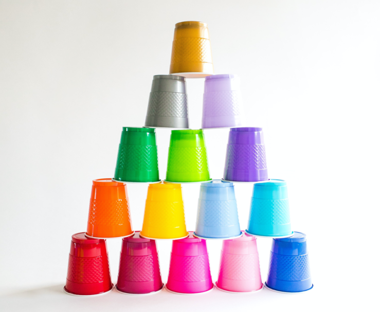 A stack of colored plastic cups, each a different color, forming a pyramid.