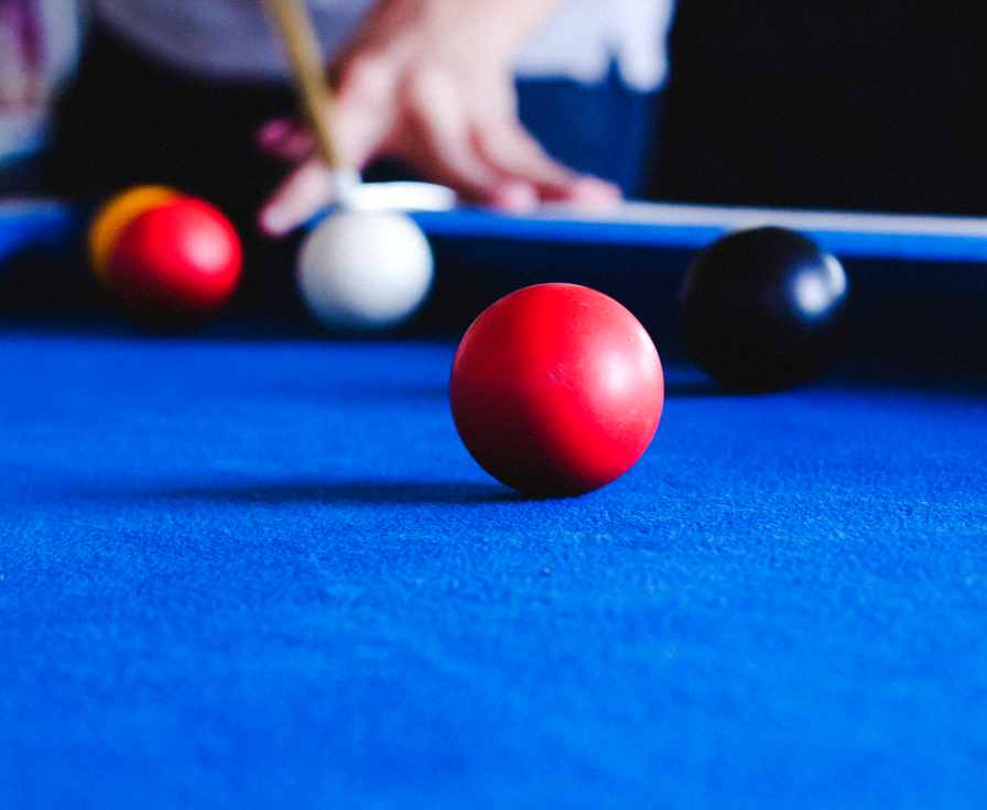 Person playing pool or similar game.