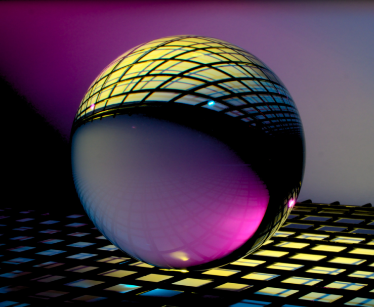 A crystal ball on top of illuminated squares.