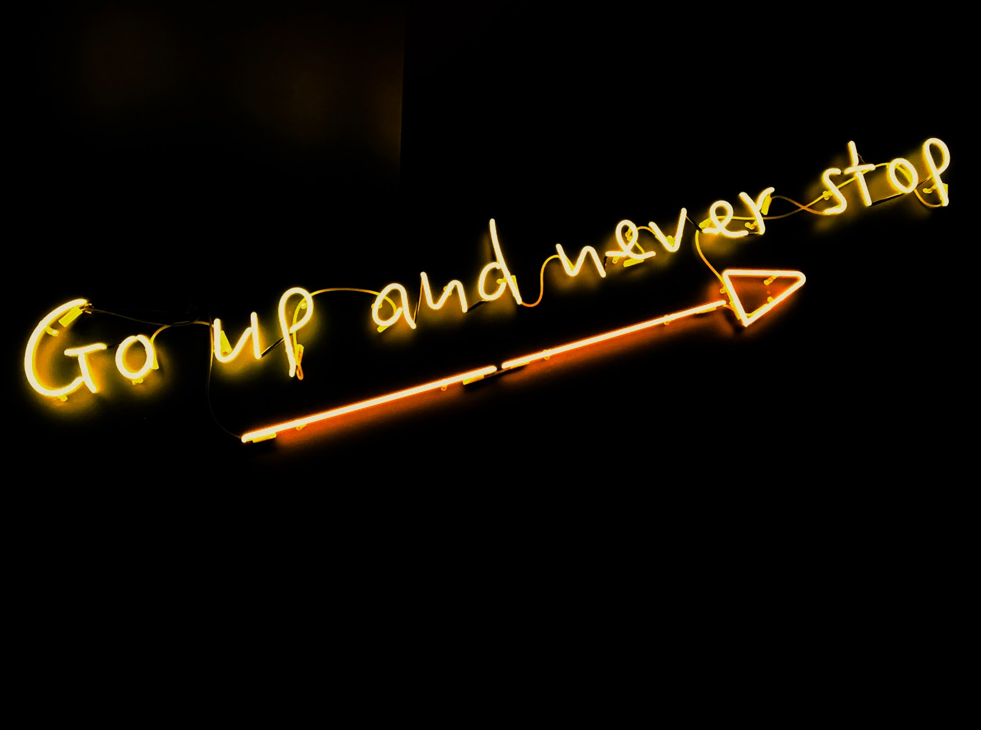 Yellow writing on a black background is positioned over an arrow pointing to the top right. The text says 