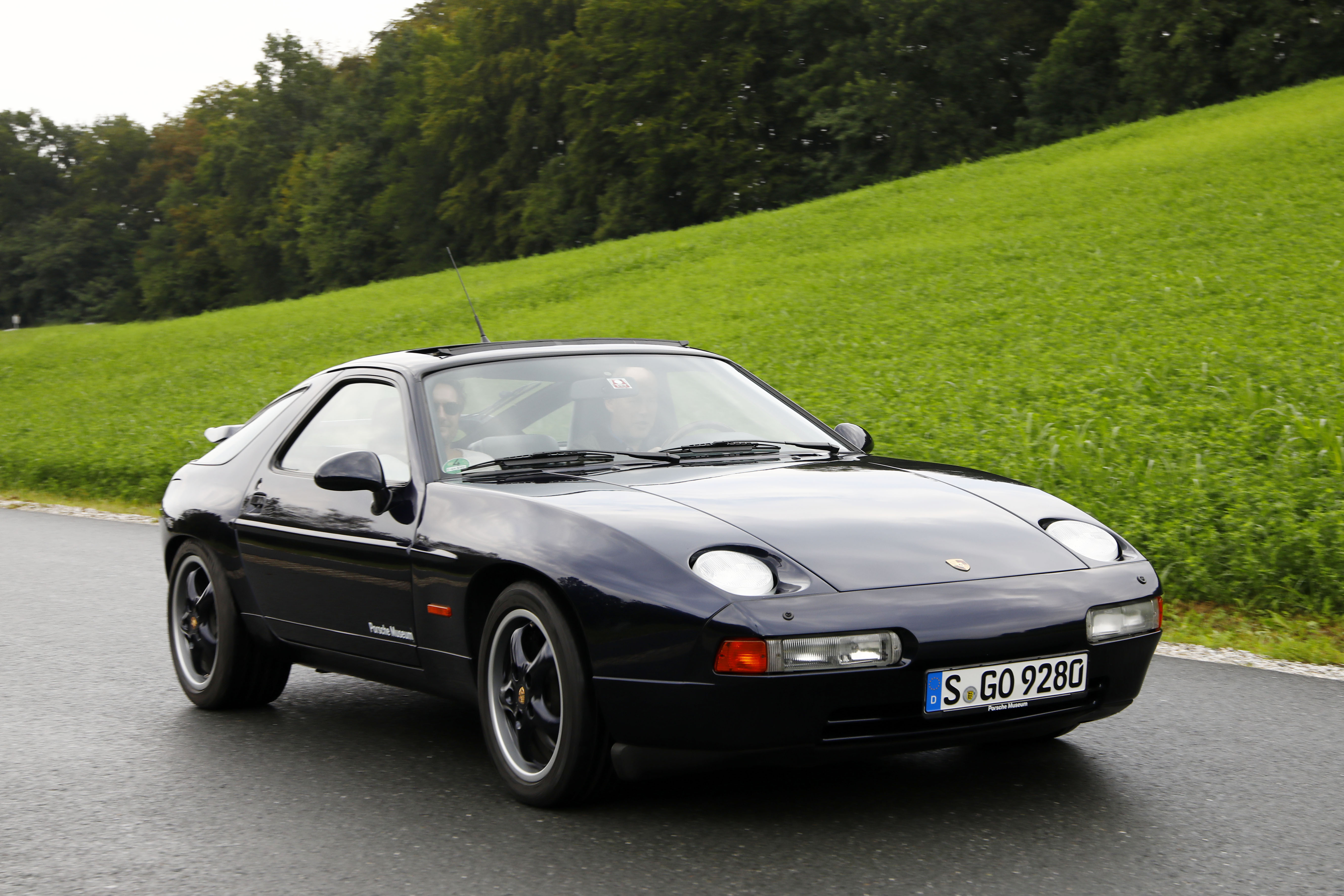 Porsche 928 GTS on wet road in countryside
