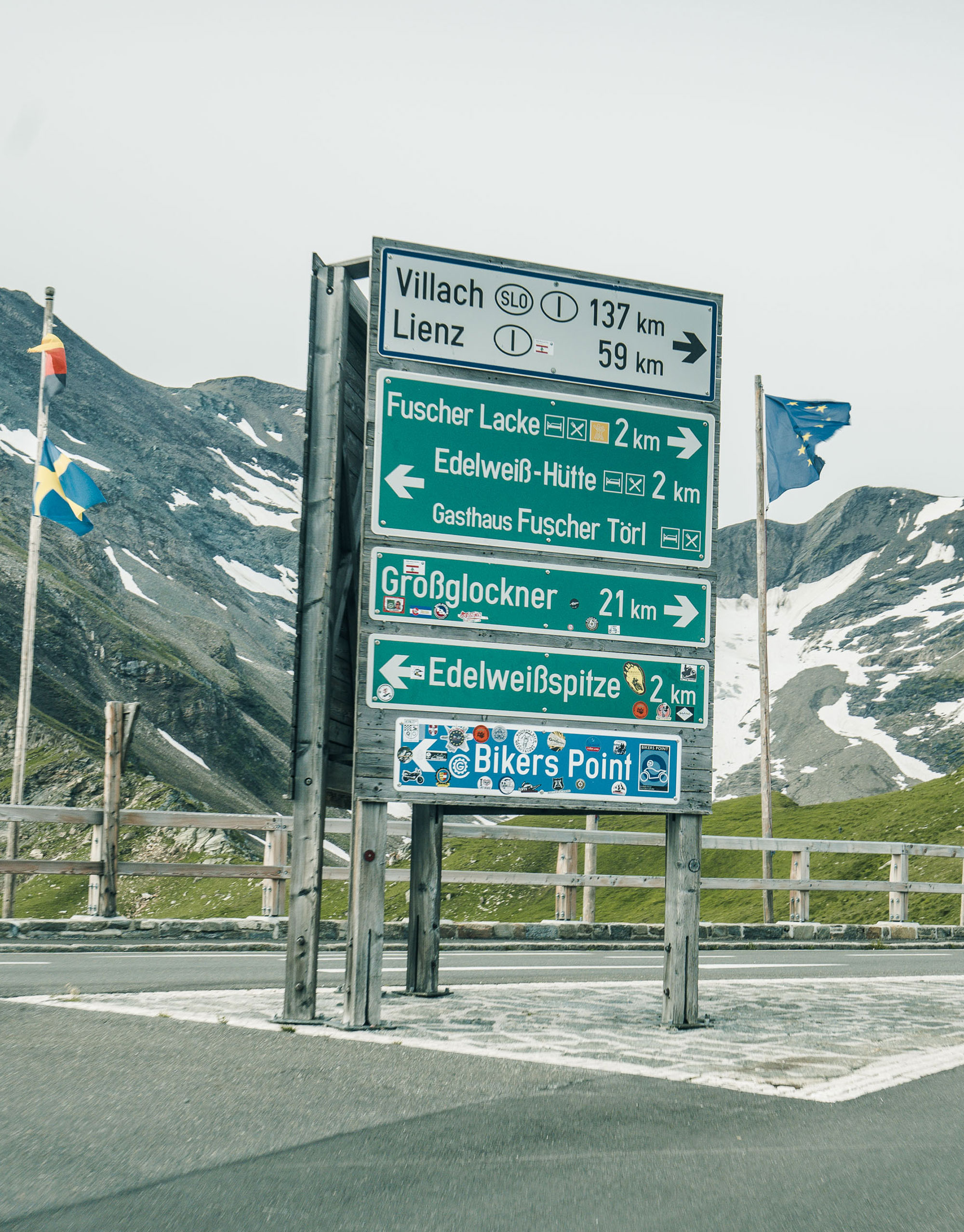 Sign saying ‘Großglockner 21km’, covered in stickers
