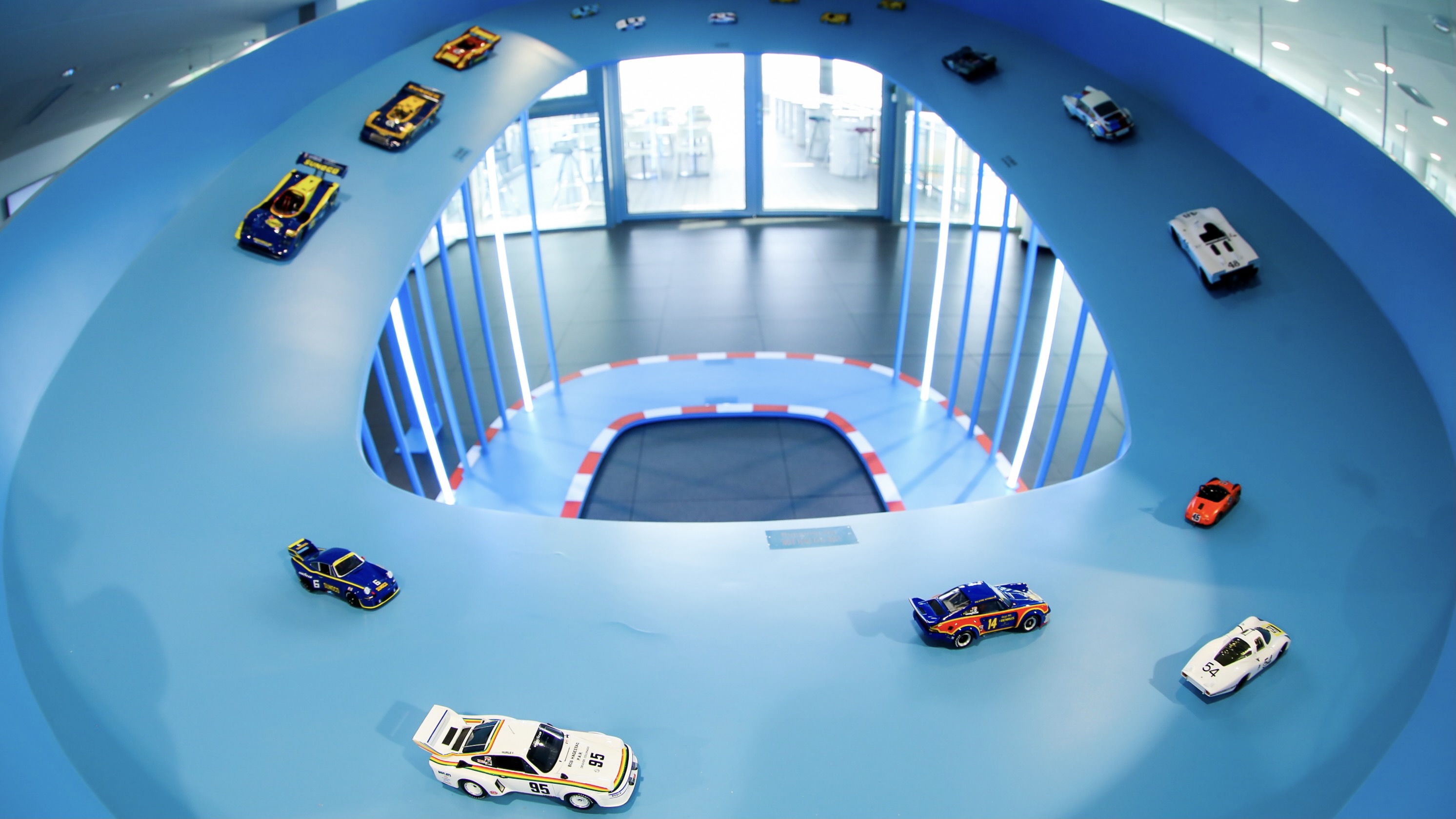 Display of model race cars circling a blue track