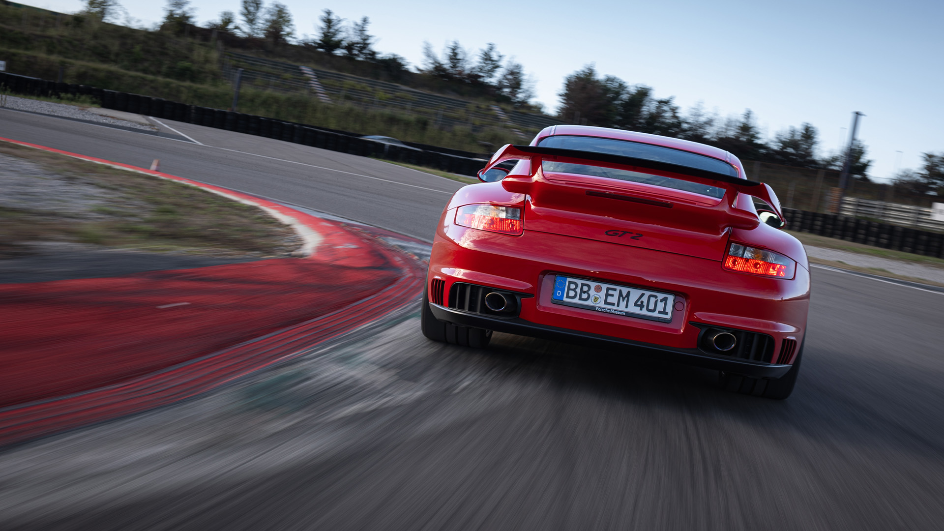 Rear view of Porsche 911 GT2 type 997 red cornering on racetrack_desktop
