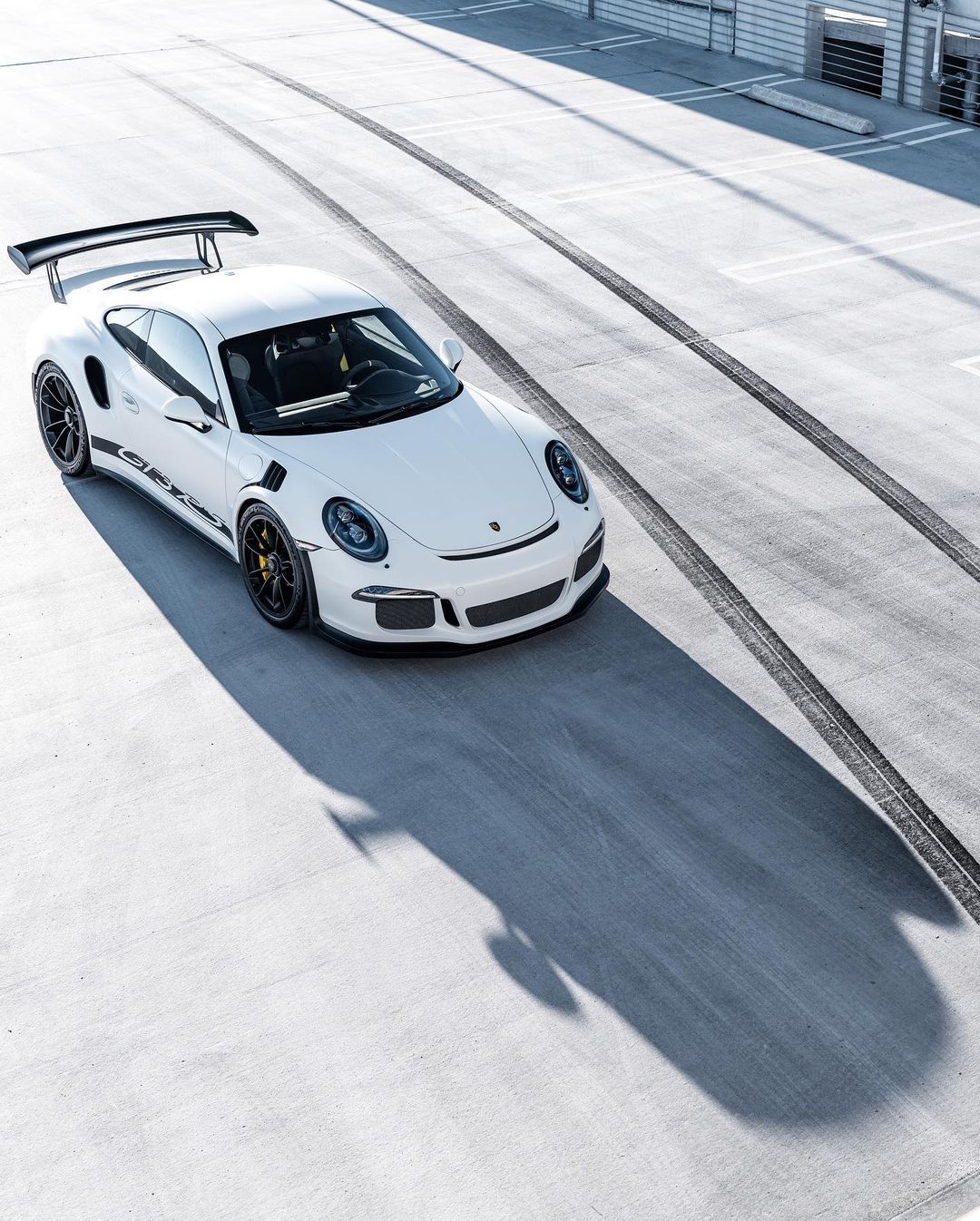 Carrera White Porsche 911 GT3 RS on racetrack, aerial view